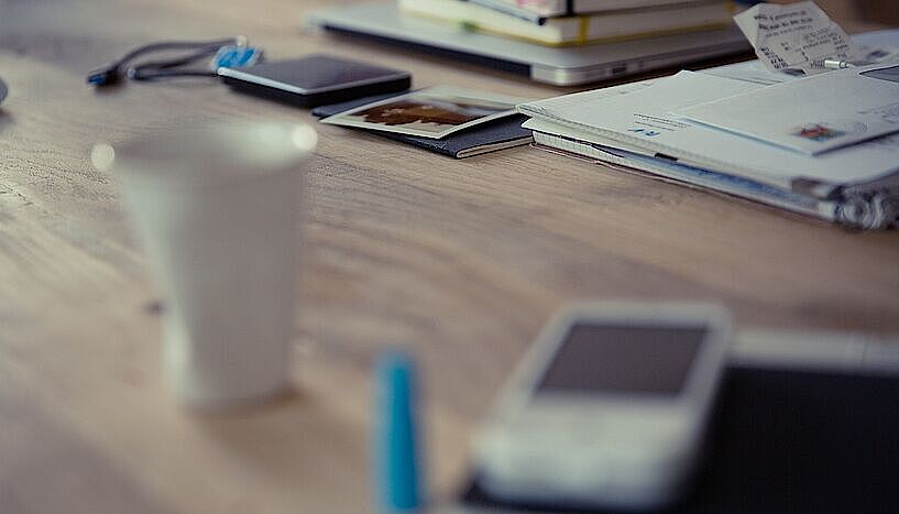 Schreibtisch mit Smartphone, Kaffeetasse, Notizbüchern