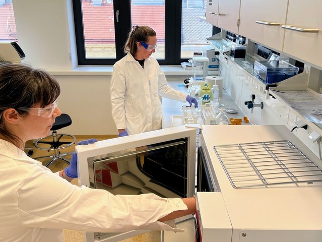 Picture of Emily. M. Pigott and Maddalena Gianni undergoing radiocarbon pre-treatment method in the Higham Lab at the University of Vienna.
