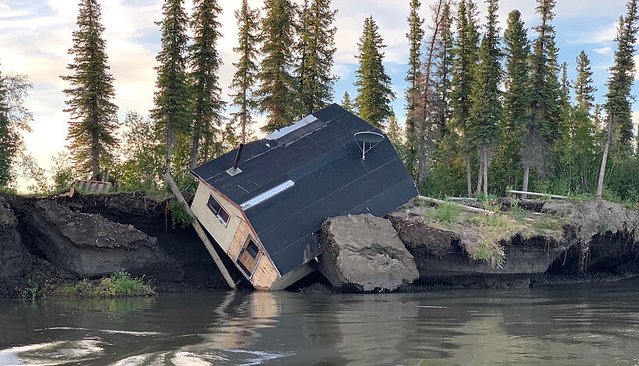A building slips in a nearby river.