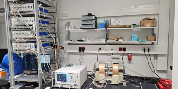 Experimenteller Aufbau mit inversem Design, bestehend aus dem Gerät selbst, das zwischen den Polschuhen eines Elektromagneten montiert ist, einem Vektornetzwerkanalysator (VNA), den fünf Mehrkanal-Stromquellen, weiteren Komponenten und einem PC, mit dem die Algorithmen zur Lösung des inversen Problems ausgeführt werden.