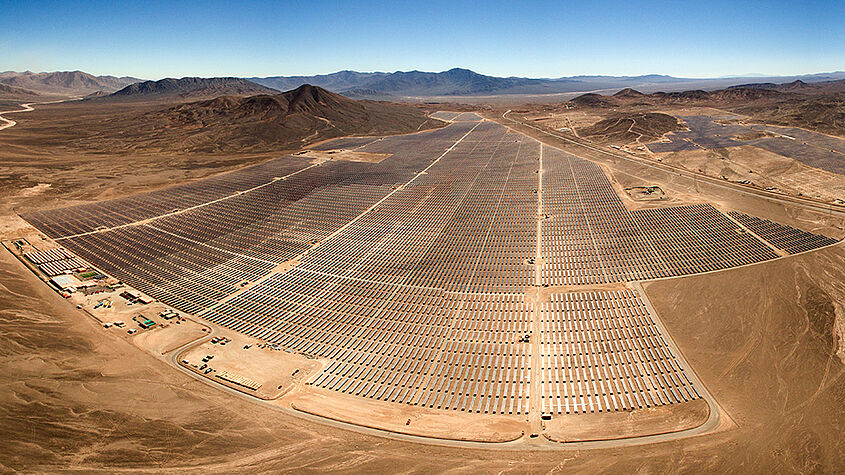 Foto von einer riesigen Fläche, die mit Photovoltaik-Anlagen zugepflastert ist.