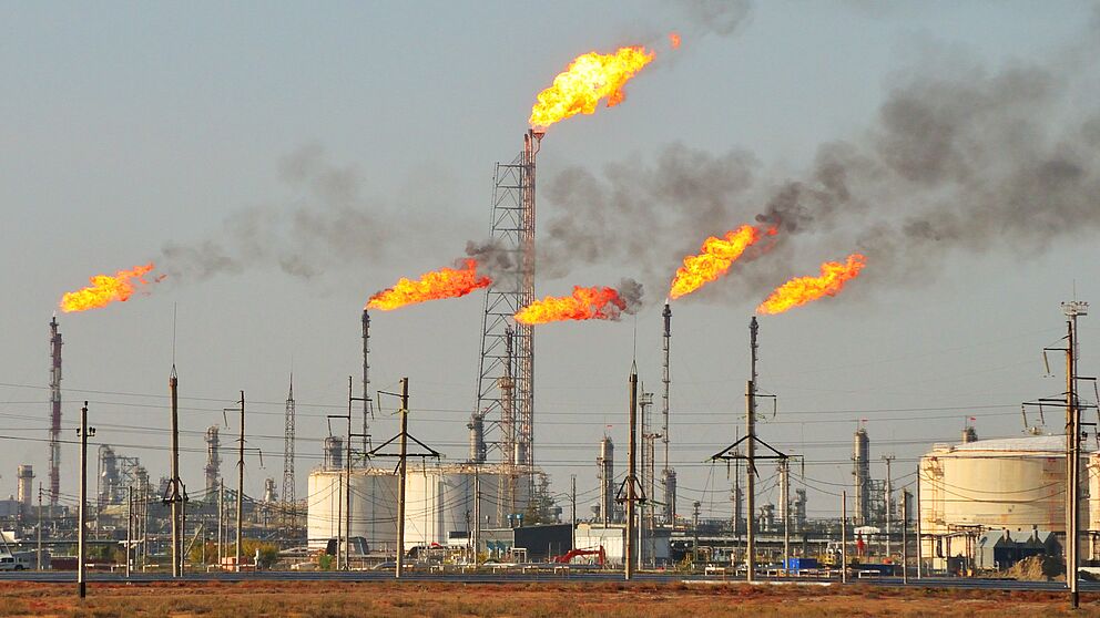Ölindustriegebiet mit Verbrennungsanlagen aus denen Feuer kommt