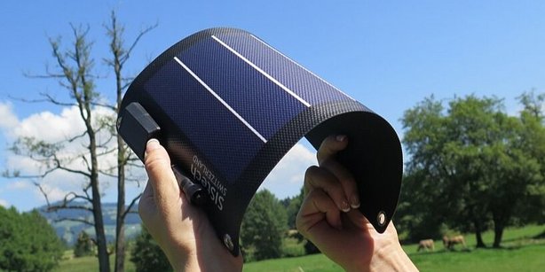 Abgebildet sind flexible Solarzellen in blauer Farbe. Im Hintergrund erkennt man Natur.