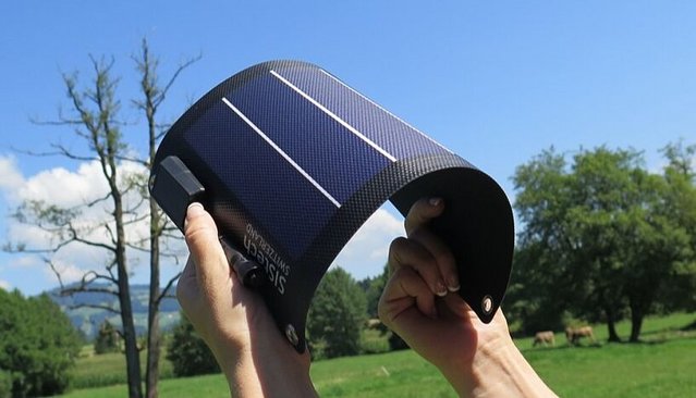 Abgebildet sind flexible Solarzellen in blauer Farbe. Im Hintergrund erkennt man Natur.