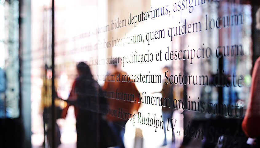 Students walking through the glass door at the main entrance at the University of Vienna