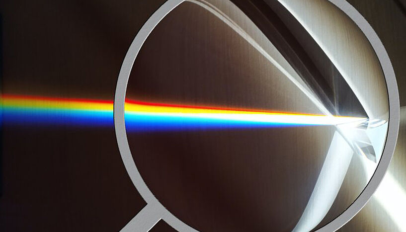 Eine computeranimierte Grafik von einem grauen Ring durch den ein Regenbogen durchbricht