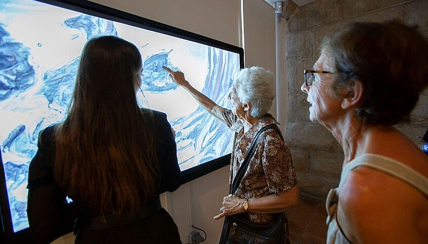 (C) ARTMYN People standing in front of a big screen:
