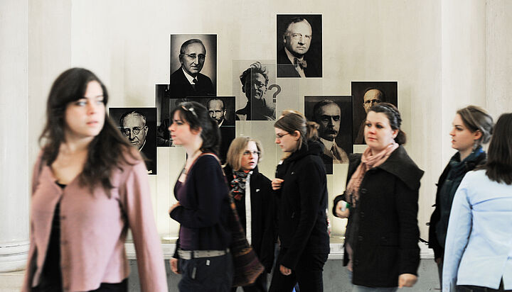 students in front of pictures of famous scientists