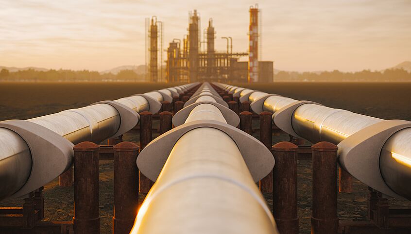 Foto von einer Pipeline, dahinter Gaskraftwerk