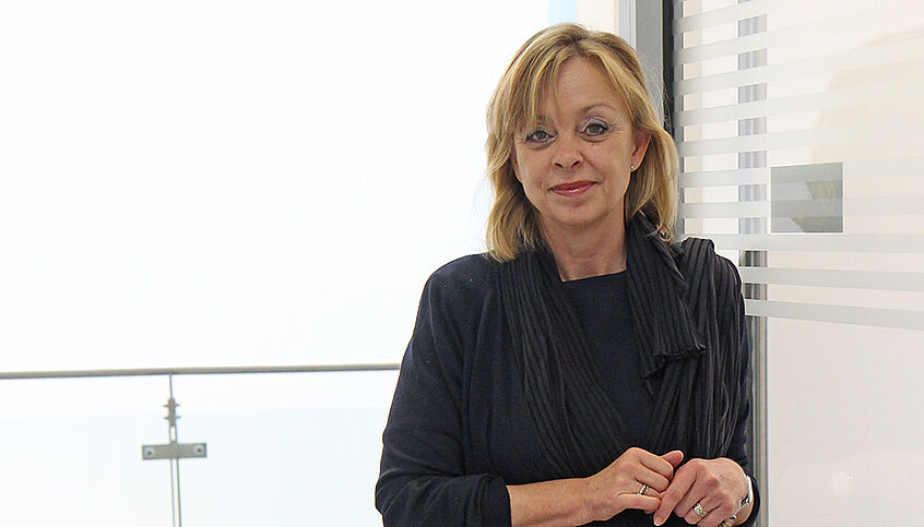© Petra Schiefer Portraitfoto von Brigitte Lueger-Schuster in einem Türrahmen lehnend.