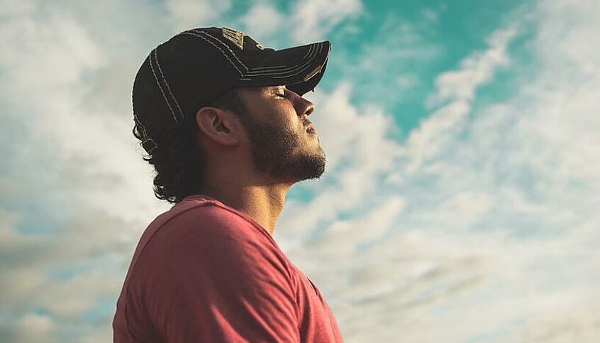 © pexels Kelvin Valerio You see a man from the side wearing a cap. He closes his eyes and practices mindfulness