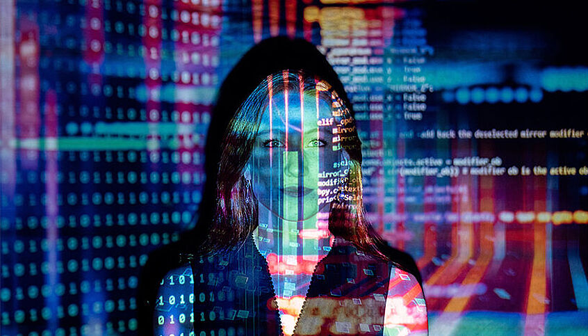 Daten vom Computer laufen über das Gesicht einer Frau
