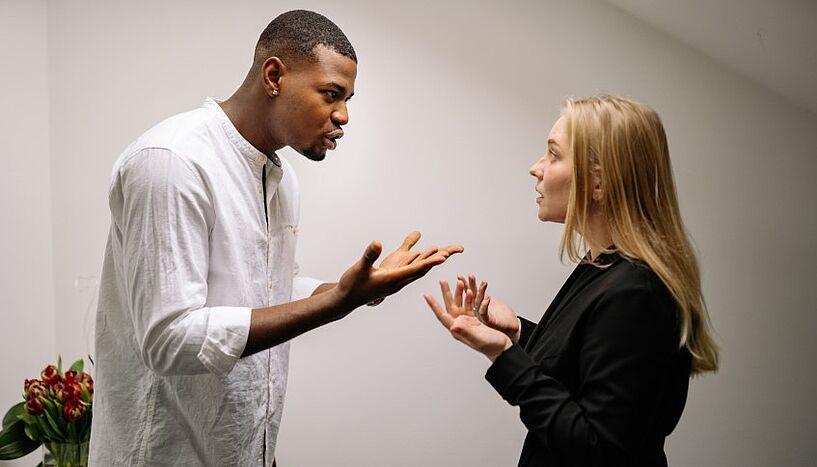 Ein Mann und eine Frau diskutieren und gestikulieren dabei mit ihren Händen